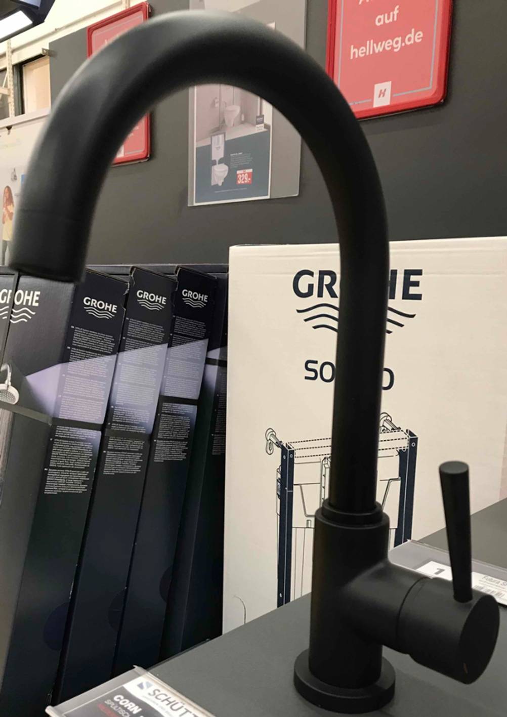 Küchenarmatur getestet: Nahaufnahme einer neuen, schwarzen Spültischarmatur mit hohem Auslauf in einem Verkaufsbereich.