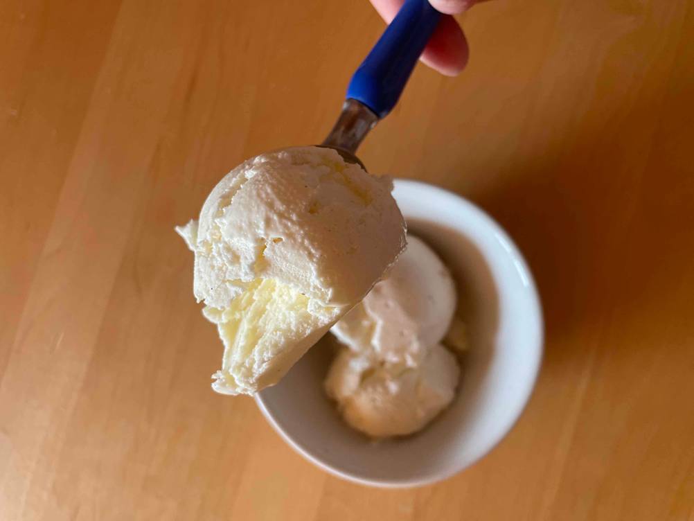 Getestet: Ein Eisportionierer mit Eis von einer Hand gehalten.