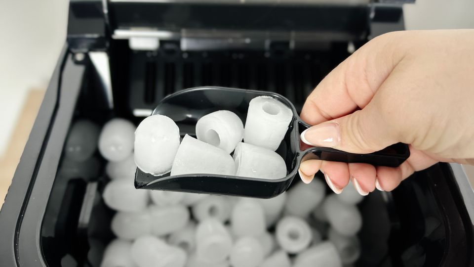 Frontansicht einer modernen Eiswürfelmaschine auf einer Küchenarbeitsplatte. Das Gerät ist ausgeschaltet.