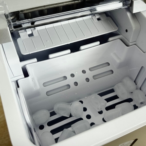 Innenansicht der Conopu ICM1227 mit wenigen Eiswürfeln im Auffangbehälter. Die Eiswürfel sind hohl und gleichmäßig geformt.