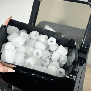 Ein herausnehmbarer schwarzer Einsatz der Kesser 14812 ist mit frisch produzierten hohlen Eiswürfeln gefüllt.