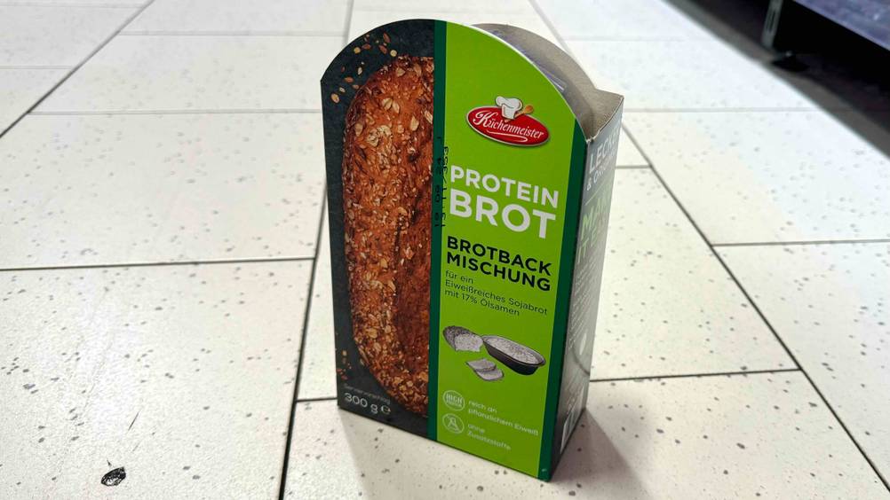 Eine Packung der getesteten Eiweißbrot-Backmischung von schräg seitlich auf einem Fließenboden.