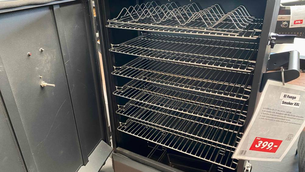 Smoker getestet: Nahaufnahme des Inneren mit Grillgittern im Vordergrund ein Preisschild.