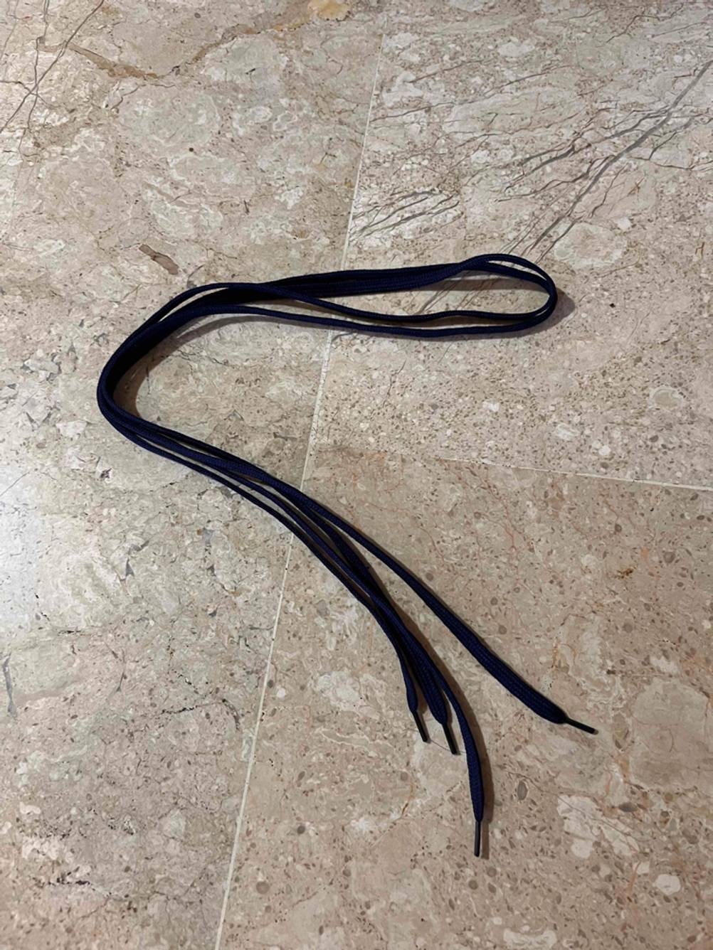 Die getesteten elastischen Schnürsenkel liegen auf dem Fußboden.