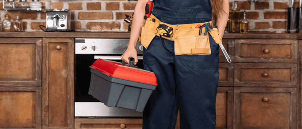 Elektriker-Werkzeugkoffer im Test: Eine Person steht mit einem Werkzeugkoffer in der Küche.