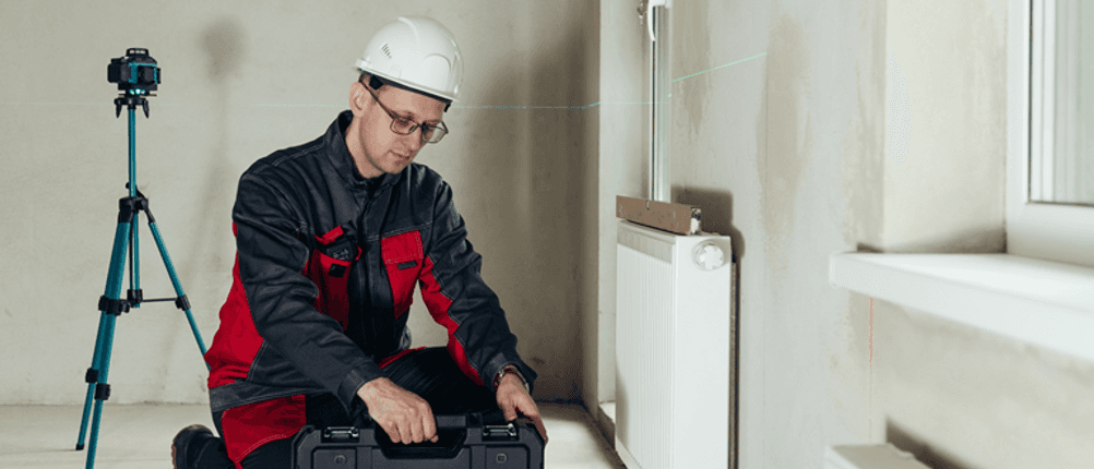 Elektriker-Werkzeugkoffer im Test: Eine Person auf einer Baustelle kniet neben einem Werkzeugkoffer.