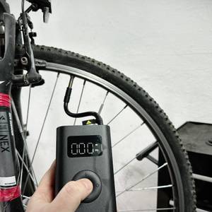 Die Xiaomi-Fahrradpumpe pumpt einen Reifen auf. Das Display zeigt den aktuellen Druck in PSI an.