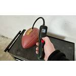 Eine Hand hält die Bosch Easypump 603947000, die mit einem Ball verbunden ist. Das Display zeigt den aktuellen und voreingestellten Luftdruck an.