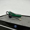 Die Bosch Easypump 603947000 liegt auf einer Werkbank, mit aufgerolltem Luftschlauch und Ventilaufsatz. Das kompakte Design ist gut erkennbar.