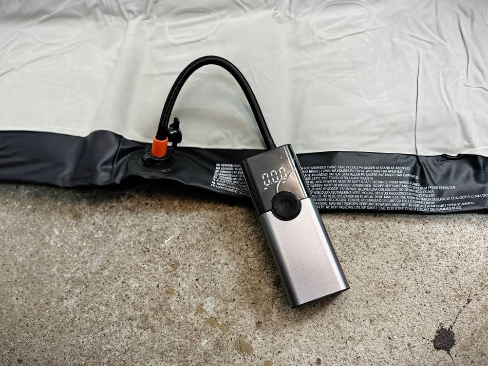 Die Zoruman CZK-3686 ist mit dem Ventil einer Luftmatratze verbunden. Das Display zeigt einen niedrigen Druck, während die Pumpe arbeitet.
