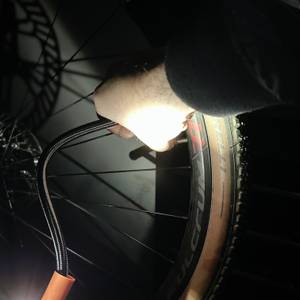 Eine Hand nutzt die integrierte LED-Leuchte der Zoruman CZK-3686, um ein Fahrradventil im Dunkeln zu beleuchten. Die Umgebung ist dunkel, nur das Licht strahlt auf das Ventil.