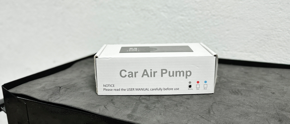 Die Verpackung der Zoruman CZK-3686 steht auf einer Werkbank. Das Design ist schlicht gehalten und zeigt das Produkt mit der Bezeichnung „Car Air Pump“.