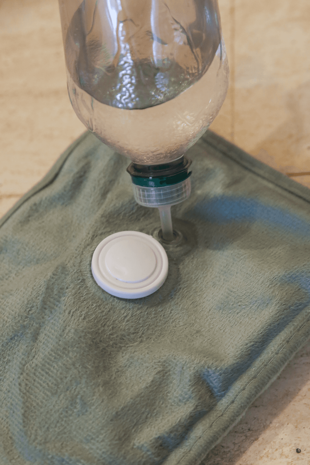 Elektrisch-Wärmflasche-Test: Eine getestete Wärmflasche wird mithilfe einer Wasserflasche befüllt.