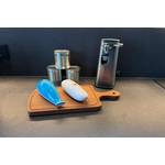 Drei elektrische Dosenöffner nebeneinander auf einem Holzbrett und einer Arbeitsplatte