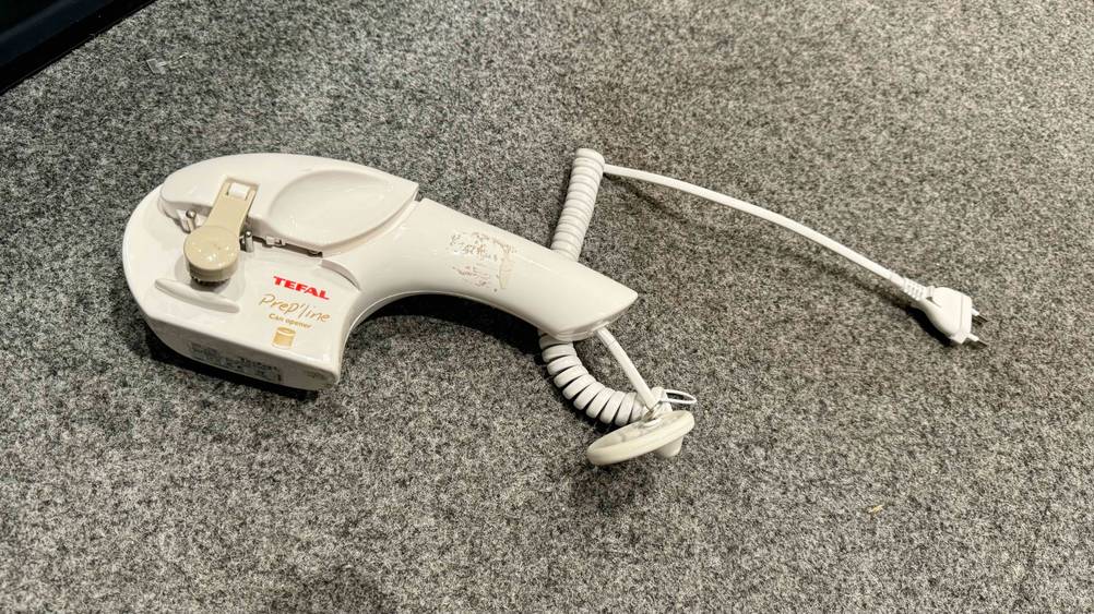 Getestet: Ein elektrischer Dosenöffner mit Kabel auf einer grauen Fläche.