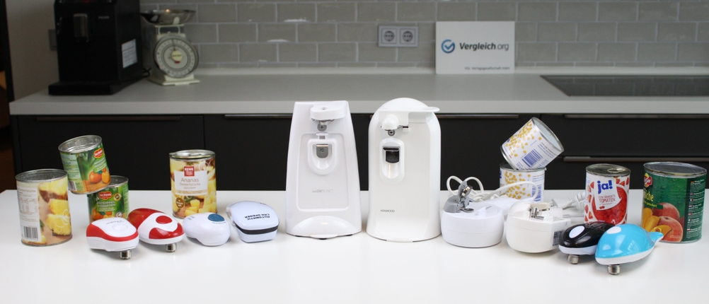 Zehn verschiedene Dosenöffner zusammen mit Dosen auf einer Küchen-Arbeitsplatte.