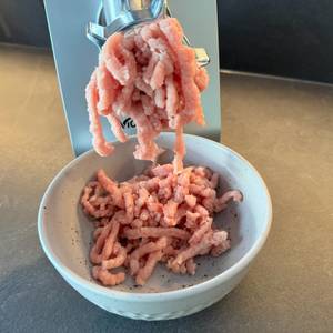 Fleisch kommt aus der Öffnung des Elektrischen Fleischwolf von Nictemaw