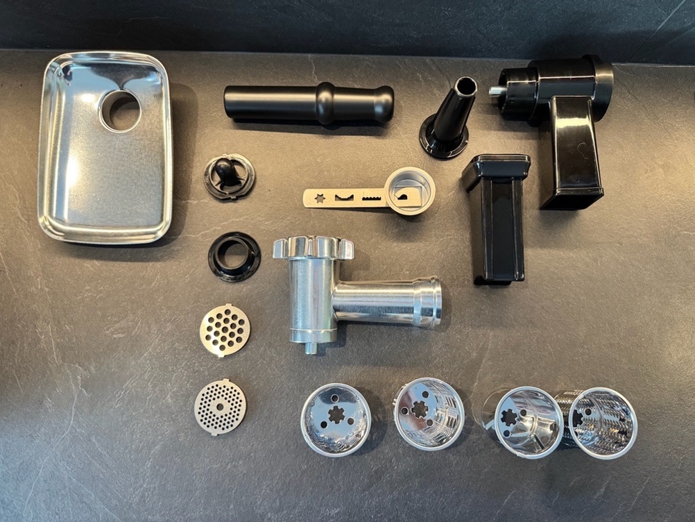 Das Zubehör des Elektrischen Fleischwolf von Nictemaw liegt auf einer Arbeitsplatte