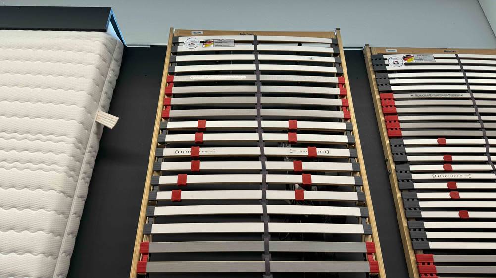 Getestet: Ein elektrischer Lattenrost 90x200 auf einer dunklen Fläche neben anderen Produkten.