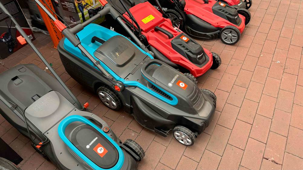 Getestet: Ein Elektro-Rasenmäher mit Mulchfunktion neben anderen Produkten in einer Verkaufsfläche.