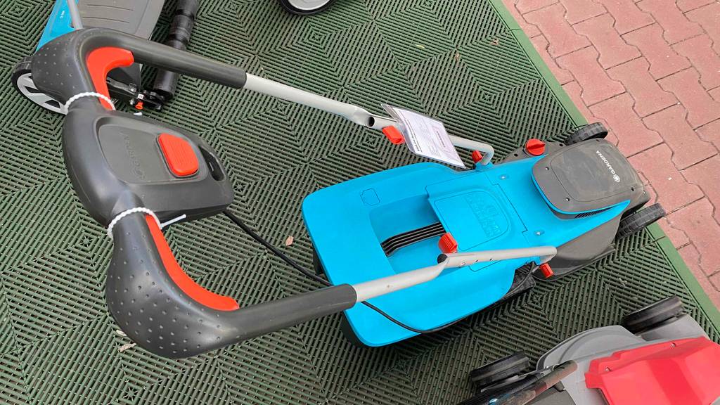 Getesteter Elektro-Rasenmäher befindet sich auf einer Gartenablage. 