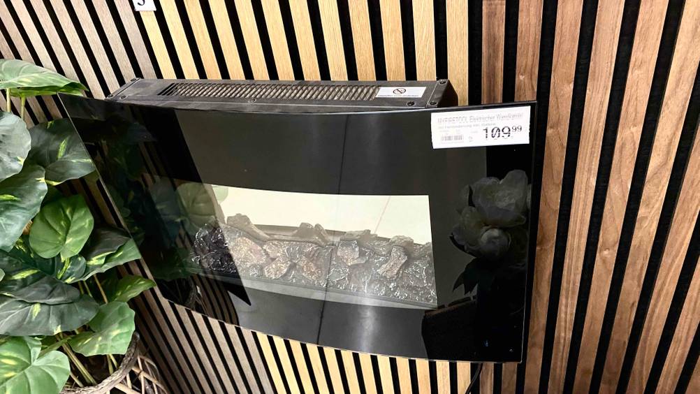Ein getesteter Elektro-Wandkamin von oben an einer Wand monitert mit Preisangaben.