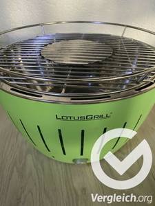Ein grüner Elektrogrill im Test steht auf Holzboden.
