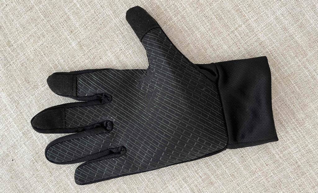 Fitness-Handschuhe-Test: ein geschlossener schwarzer Handschuh liegt auf einer beigefarbenen Oberfläche.