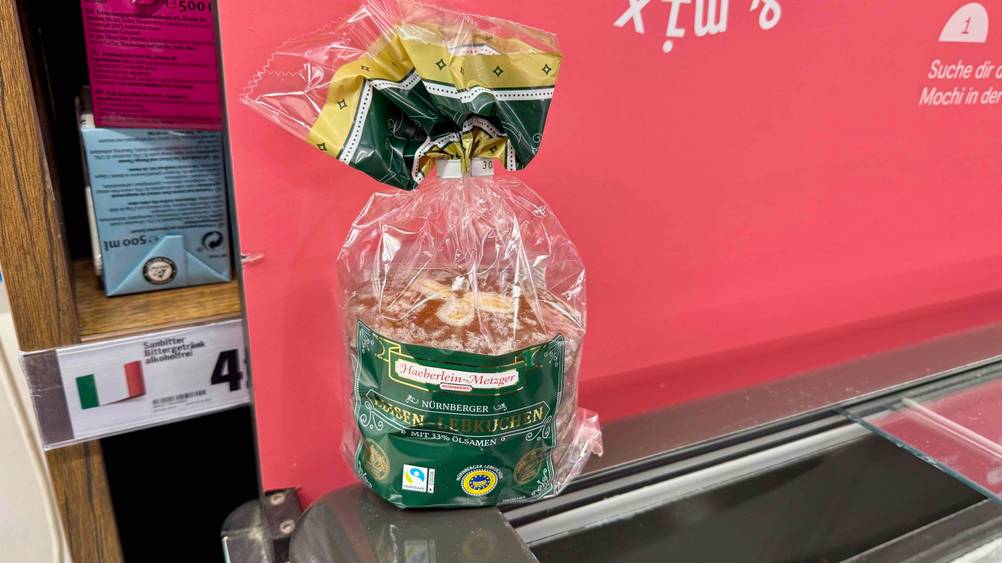 Vor einer roten Wand steht eine Packung des Elisen-Lebkuchens im Test.