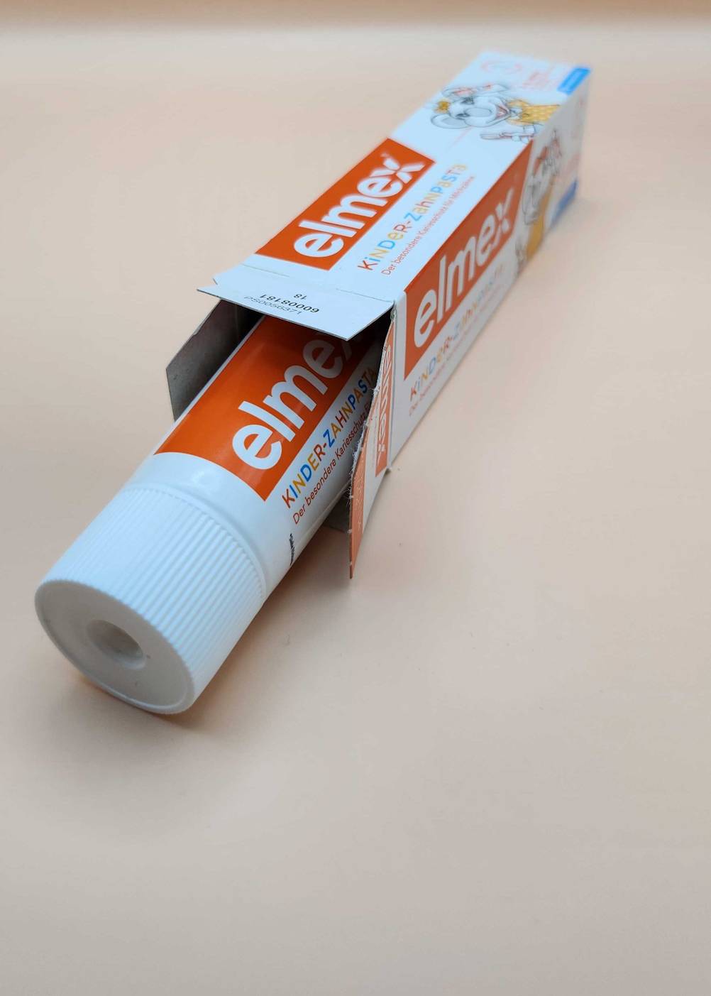 Eine Tube Elmex Zahnpasta im Test ragt zur Hälfte aus der Verpackung.