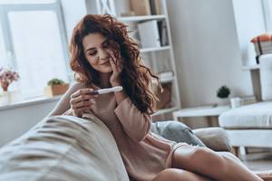 junge frau mit positiven schwangerschaftstest