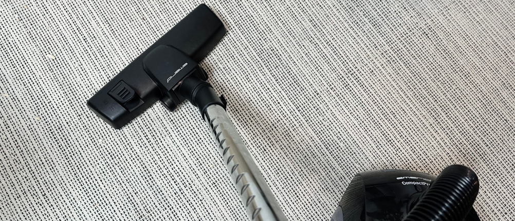 Der Emerio VE-109959.14 Staubsauger wird gerade auf einem Teppichboden verwendet. Der Fokus liegt auf der Bodendüse in Aktion.