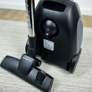 Die Rückseite des Emerio VE-109959.14 zeigt das geparkte Saugrohr. Die Parkhalterung und Rollen sind gut sichtbar.