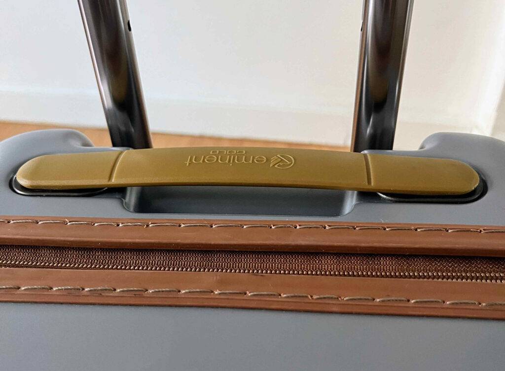 Detailansicht des ausziehbaren Metall-Handgriffs sowie des auf dem grauen getesteten leichten Koffer direkt angebrachten Handgriff.