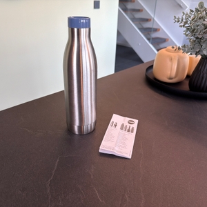 Die Emsa-Bludrop-Eco-Isolier-Trinkflasche steht neben der Anleitung auf einer Arbeitsplatte