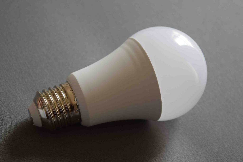 Energiesparlampen getestet: Nahaufnahme der Energiesparlampe auf einer grauen Fläche.