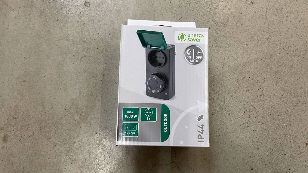 Getestete Zeitschaltuhr liegt in einer Verpackung von Energy auf dem Boden.
