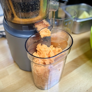 Der Kenwood PureJuice Pro gibt trockenen Karottentrester in einen durchsichtigen Auffangbehälter ab.