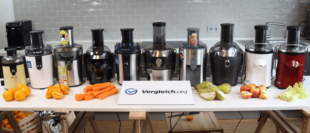 Mehrere verschiedene Modelle von Entsaftern stehen nebeneinander auf einem Tisch.