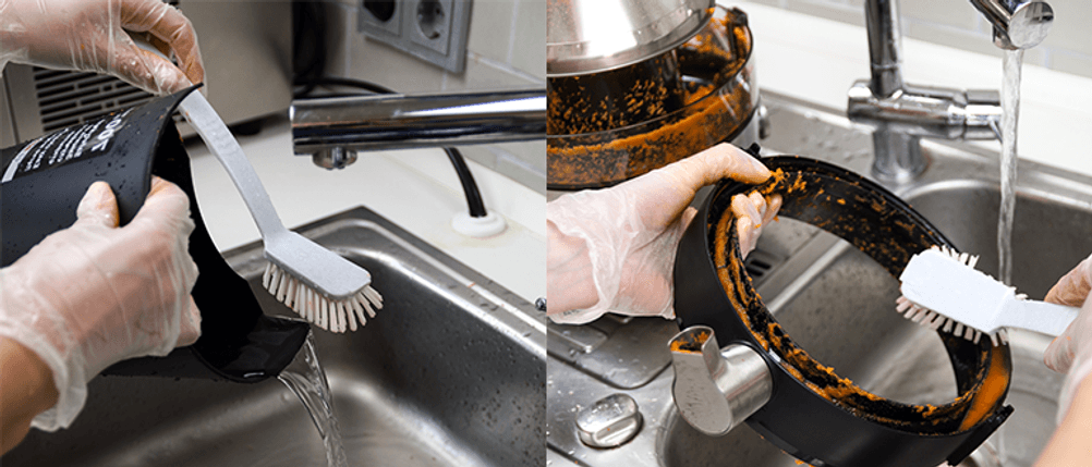 2 Tresterbehältnisse von Entsaftern werden unter der Spüle gereinigt.