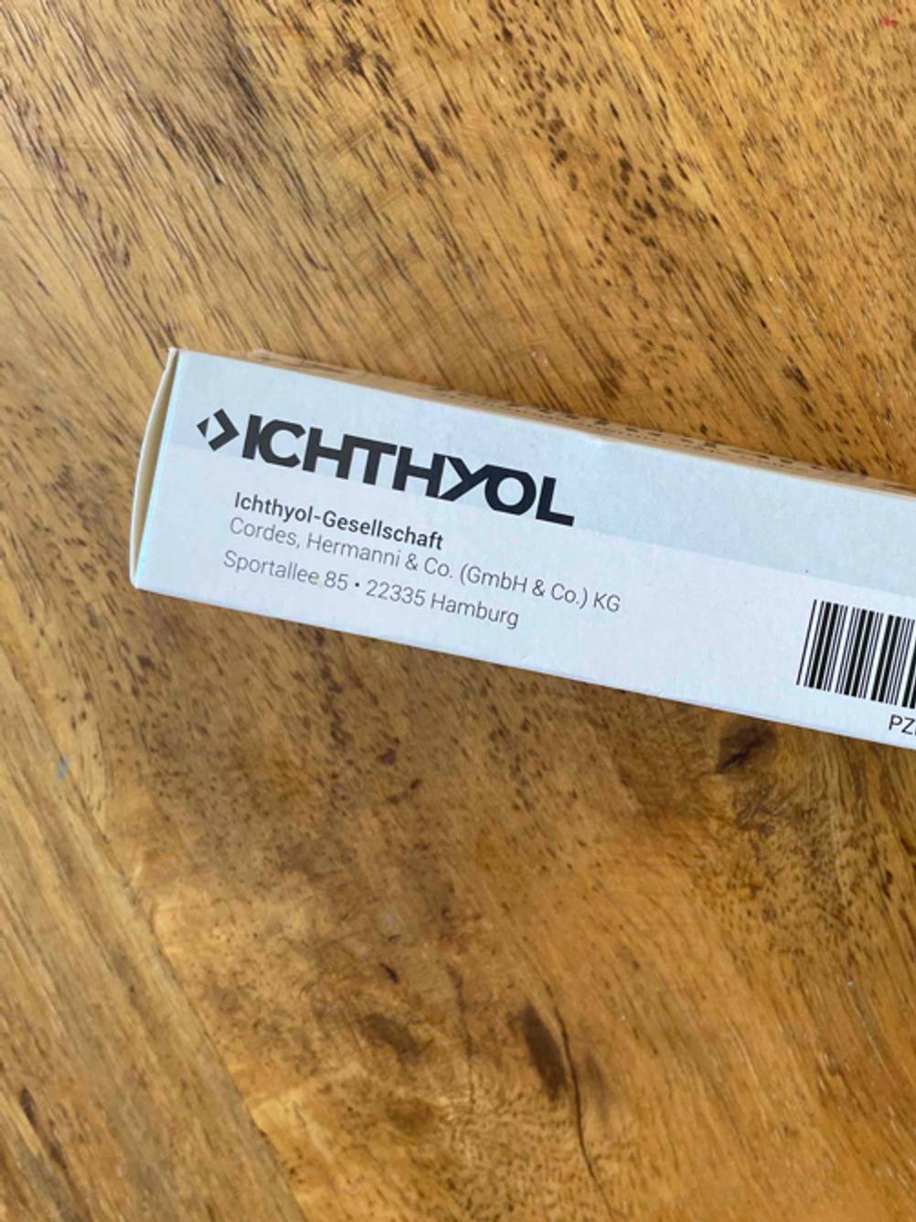 Entzündungshemmende Salbe getestet: Nahaufnahme des Logos auf der Verpackung mit Herstellerangaben.