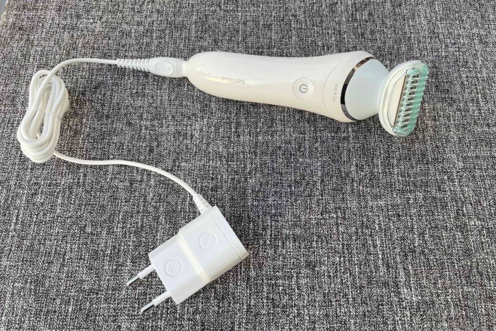 Gesamtansicht des liegenden Epilierers mit einem Ladekabel im Test.