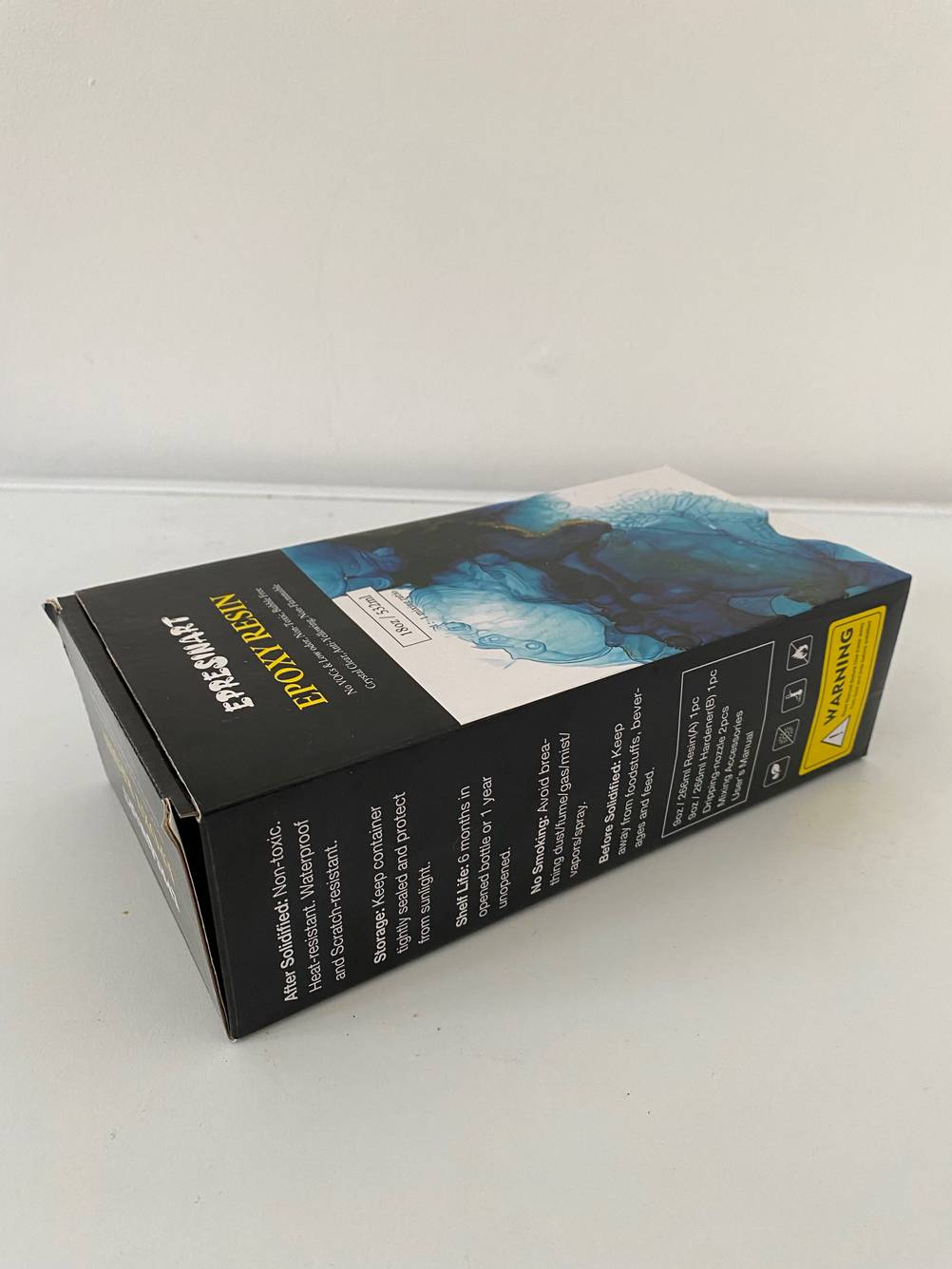 Seitenansicht einer Verpackung Epoxidharz im Test auf einer hellen Fläche.