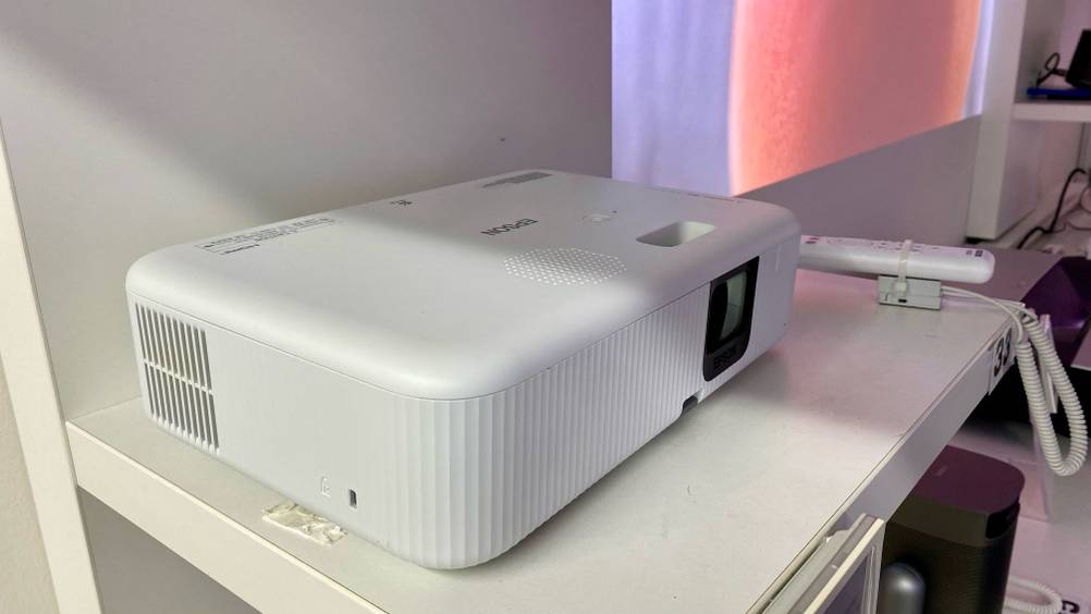 Epson-Beamer getestet: Ein Gerät von der linken Seite mit Lüftungsschlitzen daneben eine Fernbedienung.