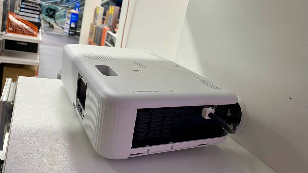 Ein getesteter Epson-Beamer von der Seite mit Anschluss auf einem Verkaufsregal.