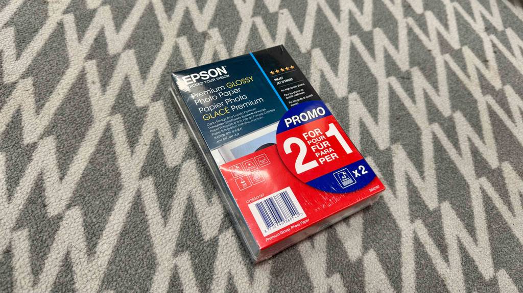 Eine Packung Epson Fotopapier liegt zum testen auf einem Teppich.