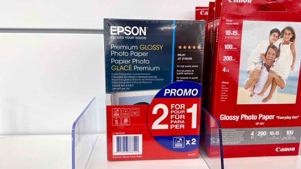 Epson Fotopapier im Test: Mehrere Packungen stehen neben Papier anderer Marken in einem Regal.