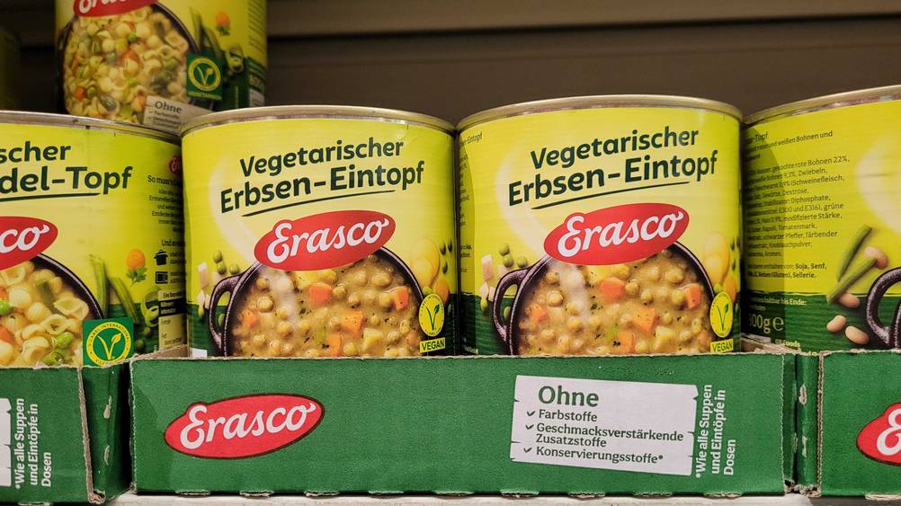 Mehrere Dosen des getesteten Erasco-Eintopfs in Kartons in einem Regal.