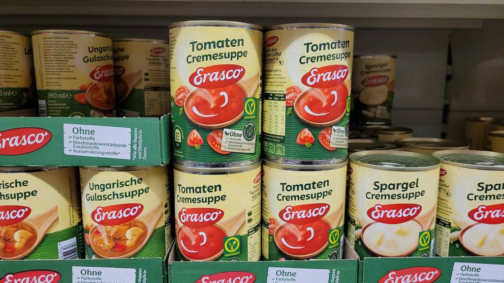 Mehrere Dosen mit getesteten Erasco-Suppen stehen in einem Verkaufsregal neben- und übereinander.