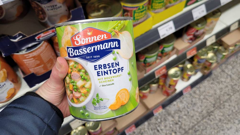 Eine Hand hält eine Dose der getesteten Erbsensuppe.